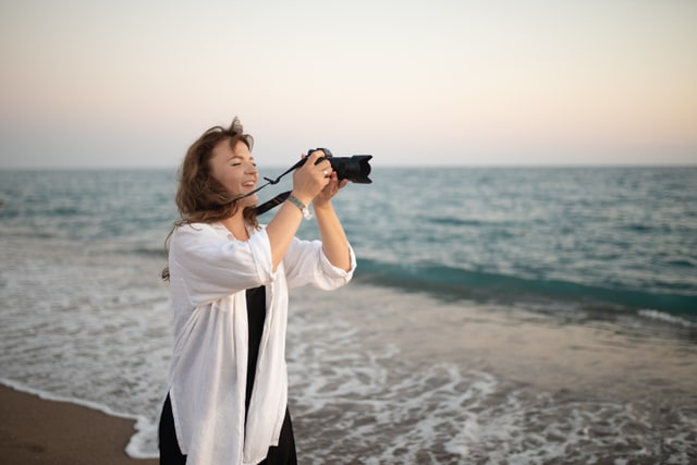 Photographer capturing images at the seaside, working with natural light