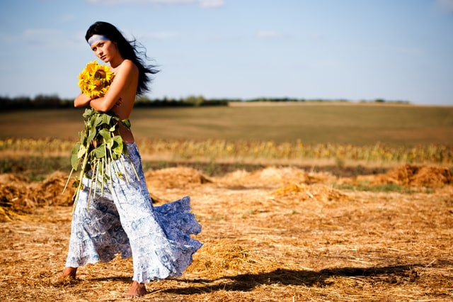 Artistic outdoor portrait of woman in golden hay field, natural and serene